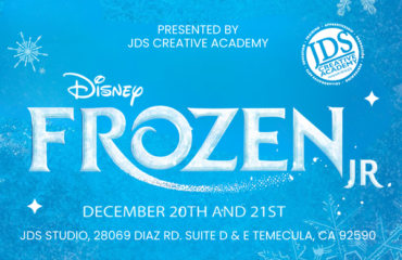 Frozen Jr. cast performing on stage at the JDS Creative Academy Winter Showcase with students in colorful costumes expressing emotion and teamwork